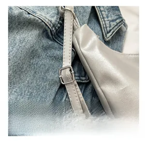 Close-up of adjustable silver metal buckle and stitching on grey PU leather strap