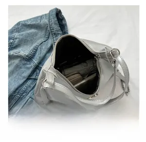 Top view of spacious silver PU bag interior holding an umbrella, wallet, and notebook