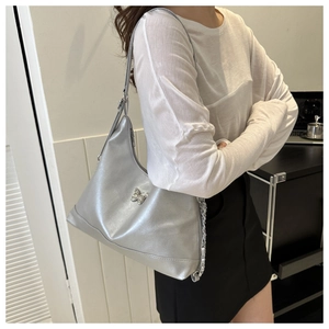 Detail of silver PU leather bag featuring a butterfly buckle and stylish metal chain strap