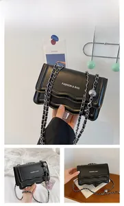 Detail of black chain bag with wavy edges and FASHION & BAG printed logo on front