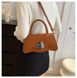 Brown crocodile pattern handbag featuring a unique wavy bottom and silver twist lock detail