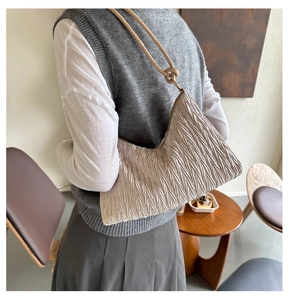 Detail van beige geplooide satijnen hobo tas met een stijlvolle geknoopte schouderband
