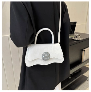 White crocodile pattern handbag featuring a unique wavy base and silver metal buckle