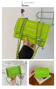 Detail of green PU leather shoulder bag with wavy flap and silver chain strap details