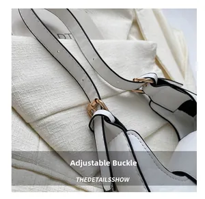 Vue macro de la boucle dorée ajustable et de la sangle en cuir blanc gaufré