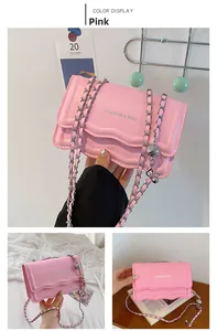 Detail of pink chain shoulder bag featuring wave edges and silver metallic ball pendant