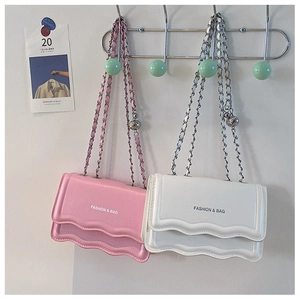 Détail de sacs à bandoulière roses et blancs avec bords festonnés et chaîne argent