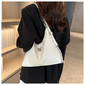 Detail of white PU shoulder bag with silver metal butterfly ornament and chain strap