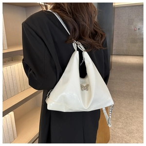 Detail view of white PU leather bag with silver butterfly buckle and chain strap