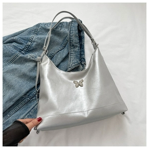 Close-up of silver PU leather bag with metallic butterfly detail and sleek chain strap