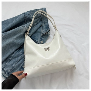 Detail of silver butterfly ornament on white soft PU leather shoulder bag with Y2K style