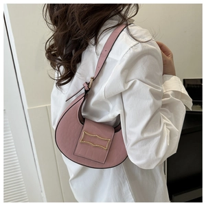 Gros plan détaillé du sac hobo rose avec gaufrage crocodile et boucle dorée