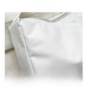 Close-up of fine lychee grain white leather texture and matching zipper on shoulder bag