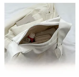 Top view of white leather crossbody bag interior showing spacious storage capacity
