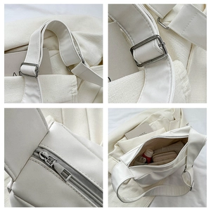 Detail view of white shoulder bag featuring wide strap, silver buckle, and inner compartment