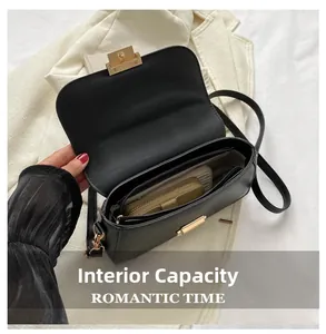 Detail view of the black leather crossbody bag interior with gold buckle and compartments