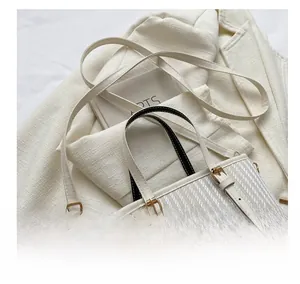 Detail of adjustable shoulder strap and textured woven pattern on the stylish bucket bag