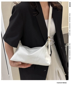 Detailed view of minimalist white leather crossbody bag with adjustable strap on model