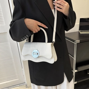 White crocodile pattern handbag with wave flap and round gold buckle on model