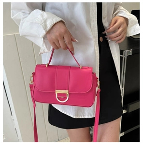 Detail view of rose pink crossbody bag with gold D-ring buckle and vegan leather handle