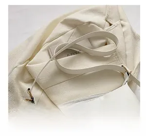 Detail view of the soft white PU leather shoulder strap with golden metal hardware