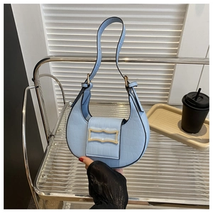 Détail du sac demi-lune bleu clair avec motif crocodile et boucle métallique dorée