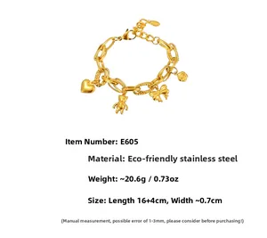 Détail d'un bracelet en acier inoxydable doré avec breloques cœur, ours et nœud