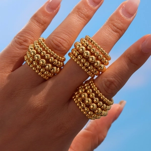 Polished multi-layer gold bead chain open ring for women shown against a blue sky background