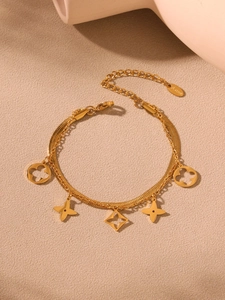 Vue détaillée du bracelet double couche en acier inoxydable doré avec trèfles