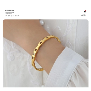 Detalle de la pulsera geométrica calada bañada en oro de 18k con circonitas brillantes