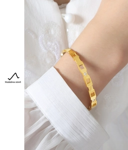 Detalle de la pulsera geométrica de acero inoxidable bañada en oro de 18k con circonitas