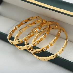 Set de cuatro brazaletes de acero inoxidable bañados en oro 18k con circonitas
