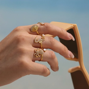 Three-piece ocean themed gold rings with seahorse shell and octopus designs set with zircons