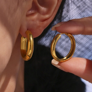 Polished 18K gold chunky hoop earrings showing side profile and on-ear wear detail
