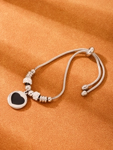 Détail du bracelet réglable argenté avec breloque cœur noir et strass brillants