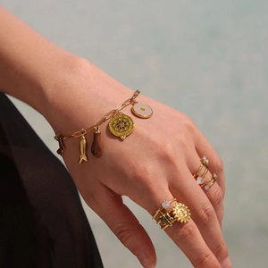 Gold multi-charm bracelet with fish pendant and sparkling heart rings for summer vacation