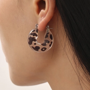 Fashionable C-shaped earrings with black and white cow print resin on silver studs