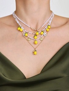 Dettaglio della collana a strati con ciondoli a limone, api e fiori di margherita