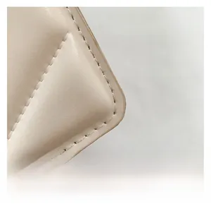 Dettaglio della trama in pelle beige e cuciture di precisione sulla borsa a busta