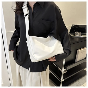 Detail of white minimalist crossbody bag with wide shoulder strap and silver metal buckle