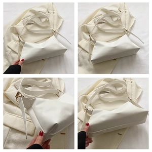 Detail of white PU leather shoulder bag featuring adjustable strap and gold metal buckles