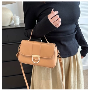 Close-up of khaki shoulder bag with a gold D-ring buckle and fine textured leather detail