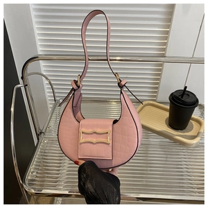 Détail du sac croissant rose à motif croco avec boucle dorée et poignée élégante