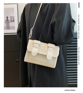Detail of woven straw and beige leather crossbody bag styled with a black blazer
