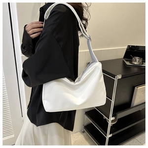 Detailed texture of soft white leather crossbody bag with wide adjustable shoulder strap