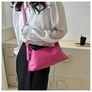 Detail shot of a soft pink PU leather crossbody bag with adjustable gold-tone buckle strap