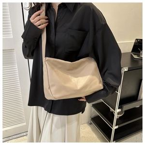 Detail of soft beige leather crossbody bag with minimalist wide shoulder strap for women