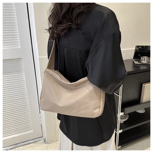 Minimalist beige shoulder bag in soft faux leather shown as side-view outfit style
