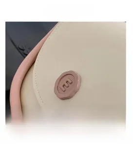 Detail of a contrast color bag showing smooth stitching and a circular E logo