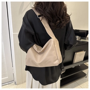 Beige Hobo shoulder bag for women shown on a model in a modern indoor lifestyle setting